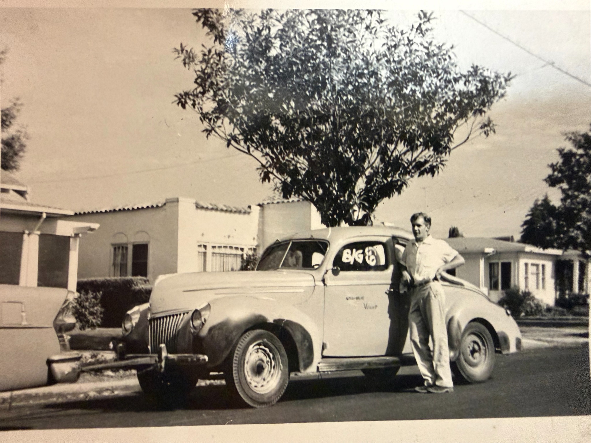 Historical photograph of a family member with a vintage Ford